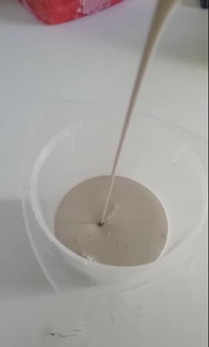 Verser liquide blanc dans récipient transparent